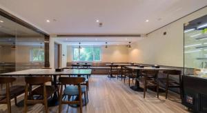 Un restaurante con mesas y sillas en una sala. en Hi Inn Shanghai Zhongshan Park Branch, en Shanghái