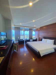 um quarto com uma cama grande e uma televisão em Khu Nghỉ Dưỡng Đoàn 298 Khu 7 Tầng em Long Hai
