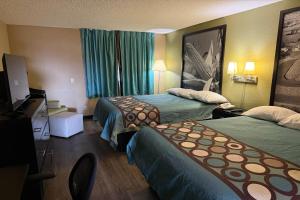 a hotel room with two beds and a television at Super 8 by Wyndham Mendota I-39 in Mendota