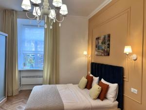 a bedroom with a bed with a window and a chandelier at Siesta apartment on Stefanyka in Lviv