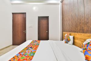 a bedroom with a large bed and wooden doors at FabHotel Anant Inn in Lucknow