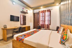 a bedroom with a bed and a desk and a television at FabHotel Anant Inn in Lucknow +19 photos