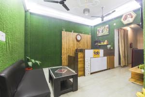 a living room with a green wall and a table at FabHotel Anant Inn in Lucknow