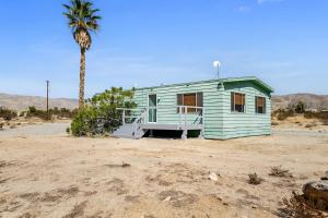 un invernadero en el desierto con una palmera en Desert Winds SkyHouse Mountain View Retreat, en Desert Hot Springs