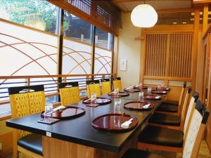 a dining room with a large black table and chairs at Albert Hotel in Dote-nagamachi