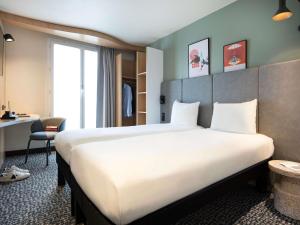 Ένα ή περισσότερα κρεβάτια σε δωμάτιο στο ibis Paris Gare de Lyon Reuilly