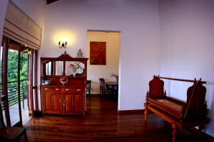 a living room with white walls and a wooden floor at Cirute' Talwatte, Kandy in Kandy
