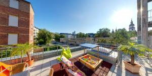 a balcony with chairs and palm trees on a building at DJH Jugendherberge Chemnitz "eins" in Chemnitz