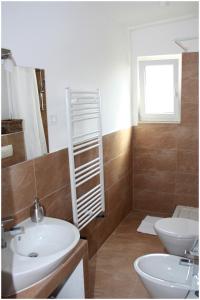 a bathroom with a sink and a toilet and a window at Apartments Ercegovic in Primošten