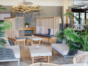 Habitación con sillas, sofá y mesas. en Pullman Port Douglas Sea Temple Resort and Spa, en Port Douglas