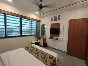 a bedroom with a bed and a flat screen tv at Hotel Earth Inn, Subhash Bridge, RTO Circle, Ahmedabad in Ahmedabad