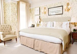 una camera con un grande letto e una sedia di The Stafford London a Londra