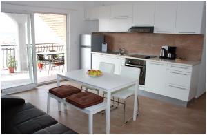 a kitchen with a white table and a white table and a table and a kitchen at Apartments Ercegovic in Primošten