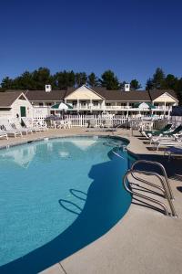 a large swimming pool with lounge chairs in a resort at Golden Gables Inn in North Conway