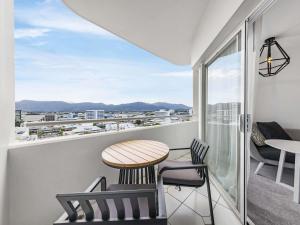 a balcony with a table and chairs and a view at Pullman Cairns International in Cairns