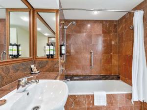 a bathroom with a tub and a sink at Pullman Cairns International in Cairns +175 photos