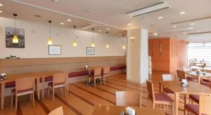 a dining room with wooden tables and chairs and a unintention at Tabist Yabuki Station Hotel in Yabuki