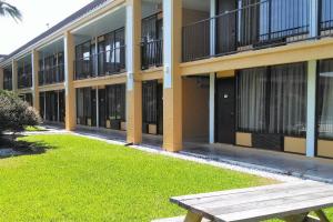 a building with a wooden bench in front of it at Econo Lodge Ormond Beach North - Daytona in Ormond Beach