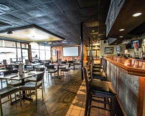 a restaurant with tables and chairs and a bar at Econo Lodge Ormond Beach North - Daytona in Ormond Beach
