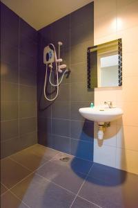 un baño con lavabo y espejo en Cappuccino Hotel @ Mount Austin, en Johor Bahru