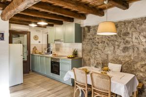 a kitchen with a table and a stone wall at El Celler - Can Bonet in Sant Martí Vell