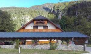 a large wooden house with a balcony on it at Apartments and Rooms Martuljk in Kranjska Gora