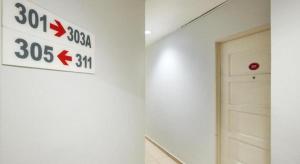 a white wall with a speed limit sign and a door at Swing & Pillows @ PJ KD in Sungai Way