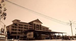 a large building with a sign in front of it at Putra Brasmana Hotel in Kuala Perlis
