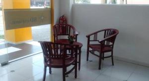 two chairs and a table in front of a store at Hotel Double Star Klang in Setia Alam