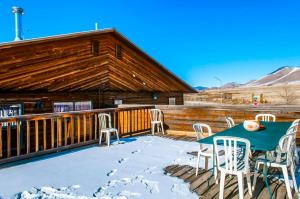 una terraza con mesa y sillas en la nieve en Enchanted Escape Lodge, en Eagle Nest
