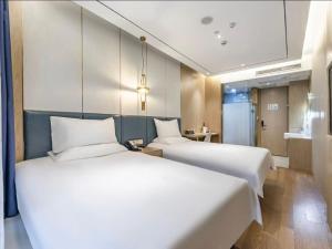 Ένα ή περισσότερα κρεβάτια σε δωμάτιο στο Hanting Hotel Shanghai South Shaanxi Road Subway Station