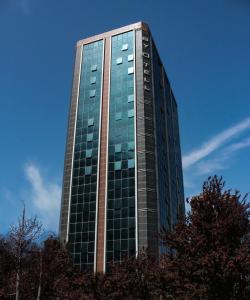 a tall glass building with trees in front of it at Byotell Istanbul in Istanbul