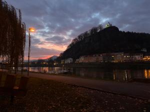 ein Hügel mit einer Burg darauf bei Sonnenuntergang in der Unterkunft Podzámčí - útulný byt na nábřeží pod zámkem in Děčín