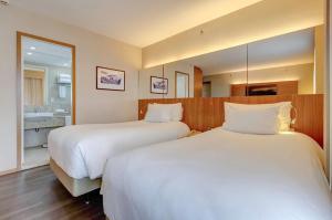 a hotel room with two beds and a bathroom at Radisson Blu São Paulo in Sao Paulo