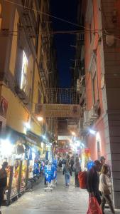 a group of people walking down a street at night at Spagno li's House in Naples