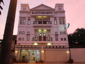 ein großes weißes Gebäude mit einem Tor davor in der Unterkunft Family & Superior Hotel Malioboro-Yogyakarta in Sentool