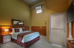 Schlafzimmer mit einem Bett, einem Fenster und einer Tür in der Unterkunft Family & Superior Hotel Malioboro-Yogyakarta in Sentool