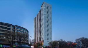 a tall building with many windows on a city street at Xana Hotelle·Xining Dashizi Central Square in Xining