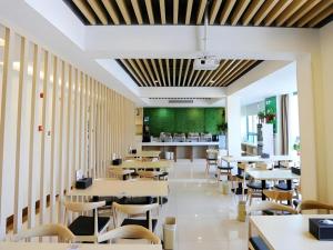 a restaurant with tables and chairs and a cafeteria at GreenTree Inn Chaohu High Speed Rail East Station in Chaohu