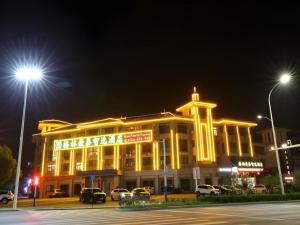 a large yellow building with cars parked in a parking lot at GreenTree Inn Chaohu High Speed Rail East Station in Chaohu