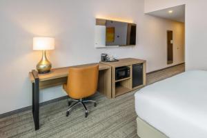 Una habitación de hotel con un escritorio, una cama y una lámpara. en Comfort Inn & Suites, en Bradford