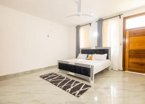 a white bedroom with a bed and a wooden door at Jamii Villas Diani in Kwale