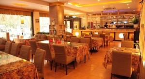 a restaurant with tables and chairs and a bar at Hong Ye Hotel in Guangzhou