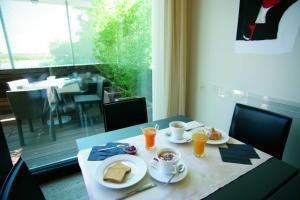 einen Tisch mit zwei Teller Essen und Orangensaft in der Unterkunft Art Hotel Udine in Udine