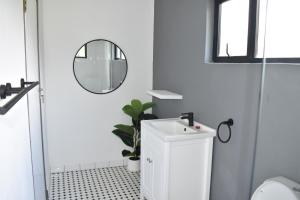 a white bathroom with a sink and a mirror at Mable's BnB 