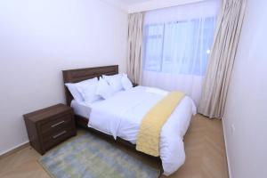a bedroom with a white bed and a window at Comfy Bnb in Syokimau +15 photos