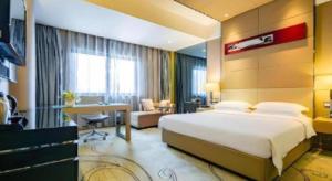 a hotel room with a large bed and a desk at Ramada by Wyndham Xi'an Bell Tower in Xi'an +43 photos
