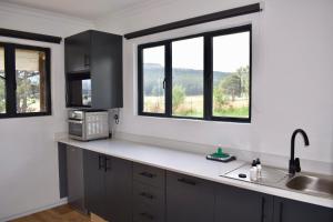 a kitchen with a sink and two windows at Mable's BnB  +27 photos
