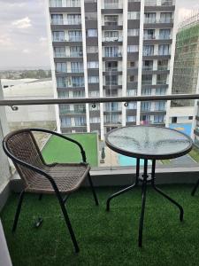 a table and chair on a balcony with a building at Comfy Bnb in Syokimau