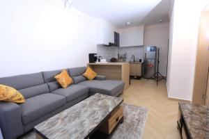 a living room with a couch and a kitchen at Comfy Bnb in Syokimau